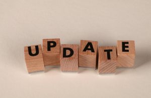 Auf dem Bild liegen kleine Holzblöcke nebeneinander. Auf jedem ist ein Buchstabe geschrieben. Die Holzklötze ergeben das Wort "Update".